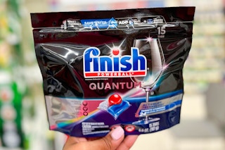 hand holding one pack of Finish Powerball quantum dishwashing tablets in aisle