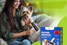 A woman holds a small dog in one hand and a pet hair removal roller in the other.