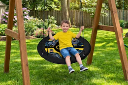 Lifestyle image of small child on Batman Saucer Swing outdoors
