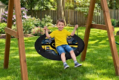 Lifestyle image of small child on Batman Saucer Swing outdoors