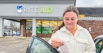 person looking at receipt in front of rite aid sign
