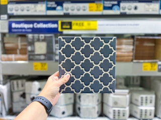Square piece of tile held in Tile aisle at Lowe's