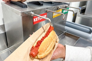 someone eating a hotdog in the costco food court