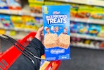 person holding a box of rice krispies treats with a cvs basket on their arm