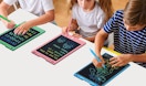 kids writing on colorful writing tablets on a table 