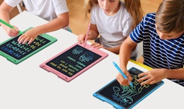 kids writing on colorful writing tablets on a table