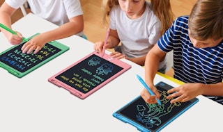 kids writing on colorful writing tablets on a table