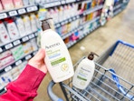 Aveeno Lotion held up over Walmart shopping cart