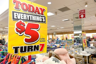 A sign that says "Today Everything's $5 in this section" on a clothing rack in a Turn7 store