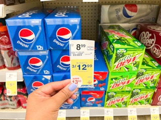 hand holding sales tag in front of pepsi products