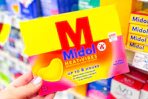hand holding midol heat patch