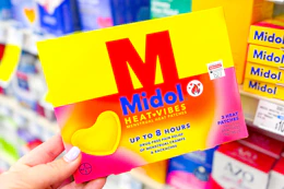 hand holding midol heat patch