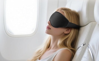 a person sleeping on a plane with a sleep mask on
