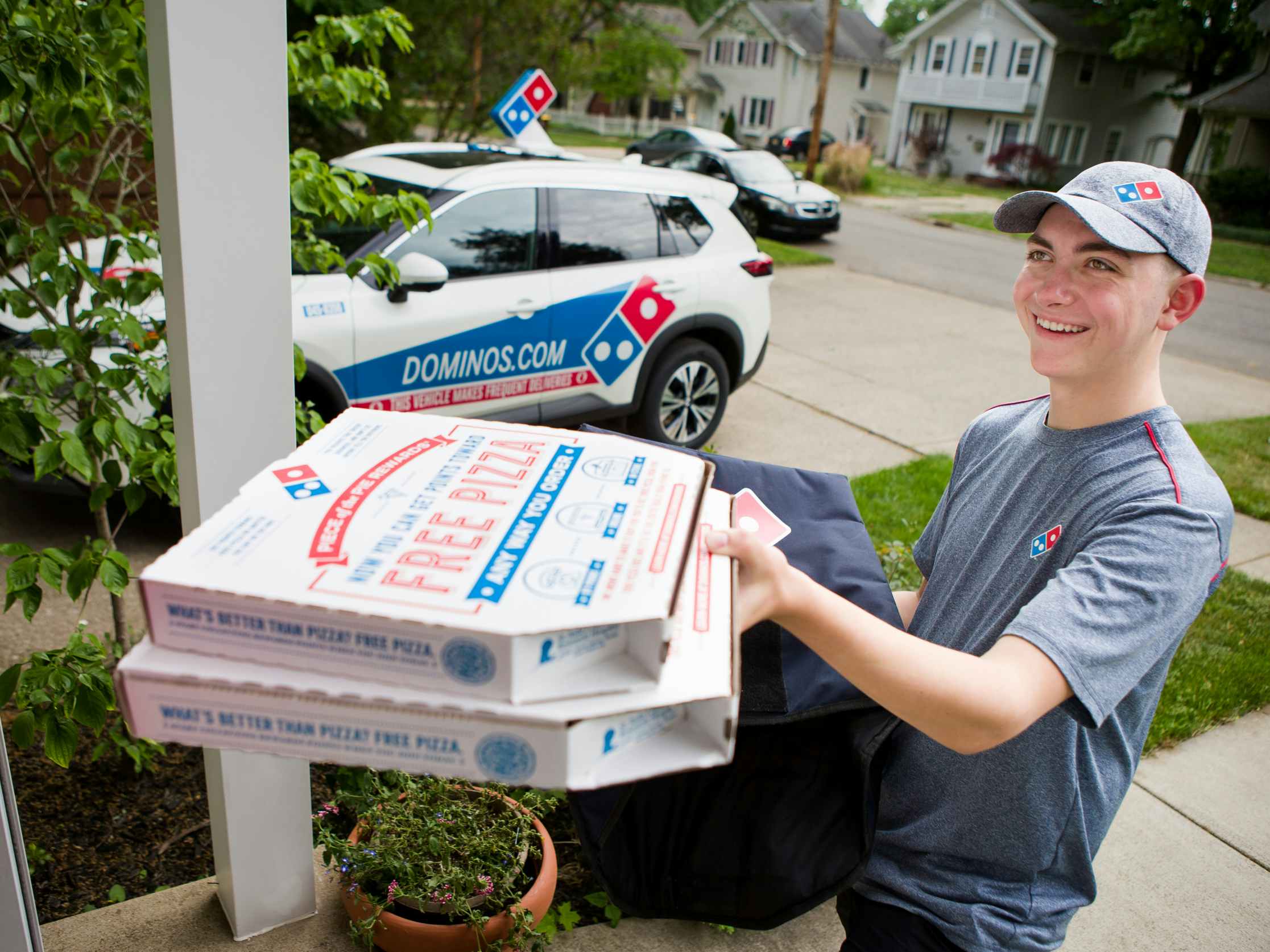 A Domino's Employee delivering pizzas to someone's house