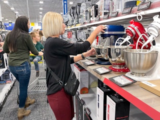 A woman looking at KitchenAid mixers at Best Buy