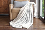 Lifestyle image of a faux fur throw blanket draped over chair