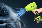 a hand holding a green cordless leaf blower 