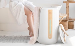 a towel warmer next to a person sitting on a bathtub