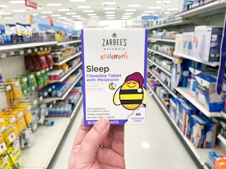 hand holding zarbee's children's sleep box in aisle