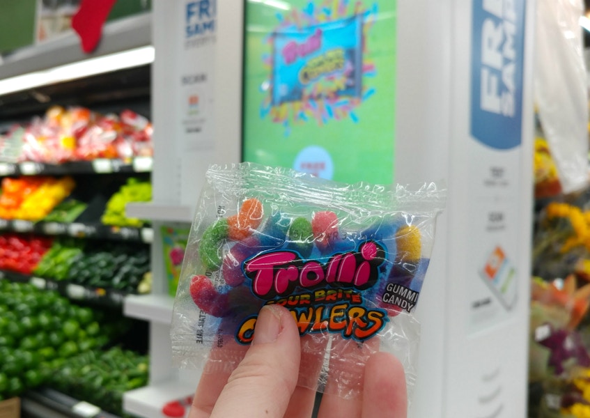 A person holding a pack of Trolli gummies.