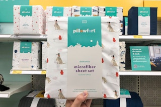 hand holding up pillowfort sheets at target
