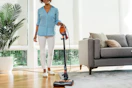 a woman using a shark vacuum