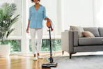 a woman using a shark vacuum