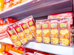 hand holding a pack of ritz crackers on walmart shelf