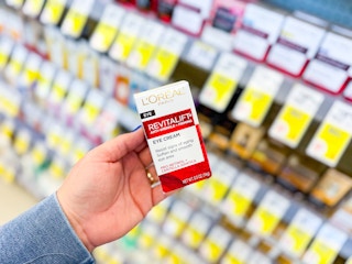 hand holding l'oreal revitalift eye cream in walgreens