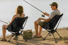 couple sitting on camping chair while fishing