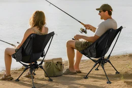 couple sitting on camping chair while fishing