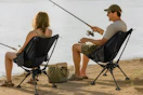 couple sitting on camping chair while fishing