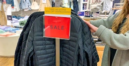 A person shopping for winter coats at GAP