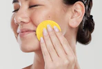a person using a turmeric cleansing pad on their face