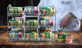 A silver rack full of cans on a wooden table