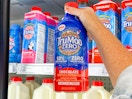 hand holding a bottle of trumoo zero sugar chocolate milk in front of a target shelf