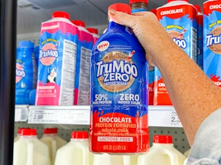 hand holding a bottle of trumoo zero sugar chocolate milk in front of a target shelf