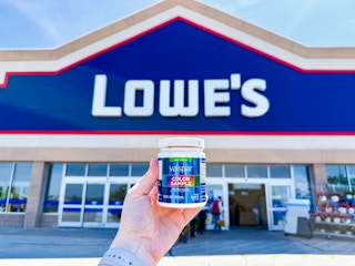 someone holding a paint sample outside of lowes