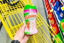 hand holding gain fireworks tango scent booster above a yellow shopping cart