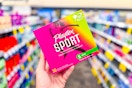 person holding a box of tampons in an aisle