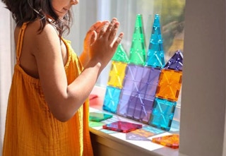 child playing with a Magna-Tiles set in a window