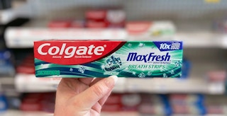 hand holding a Colgate MaxFresh toothpaste