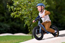 Lifestyle image of a small boy riding a Ozark balance bike outdoors