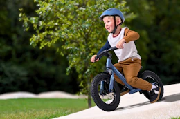 Lifestyle image of a small boy riding a Ozark balance bike outdoors