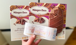 hand holding two haagen dazs ice cream bars and a walgreens catalina coupon in front of a fridge