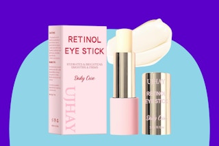 A box and a tube of retinol eye stick with the lid off and a glob of cream behind it