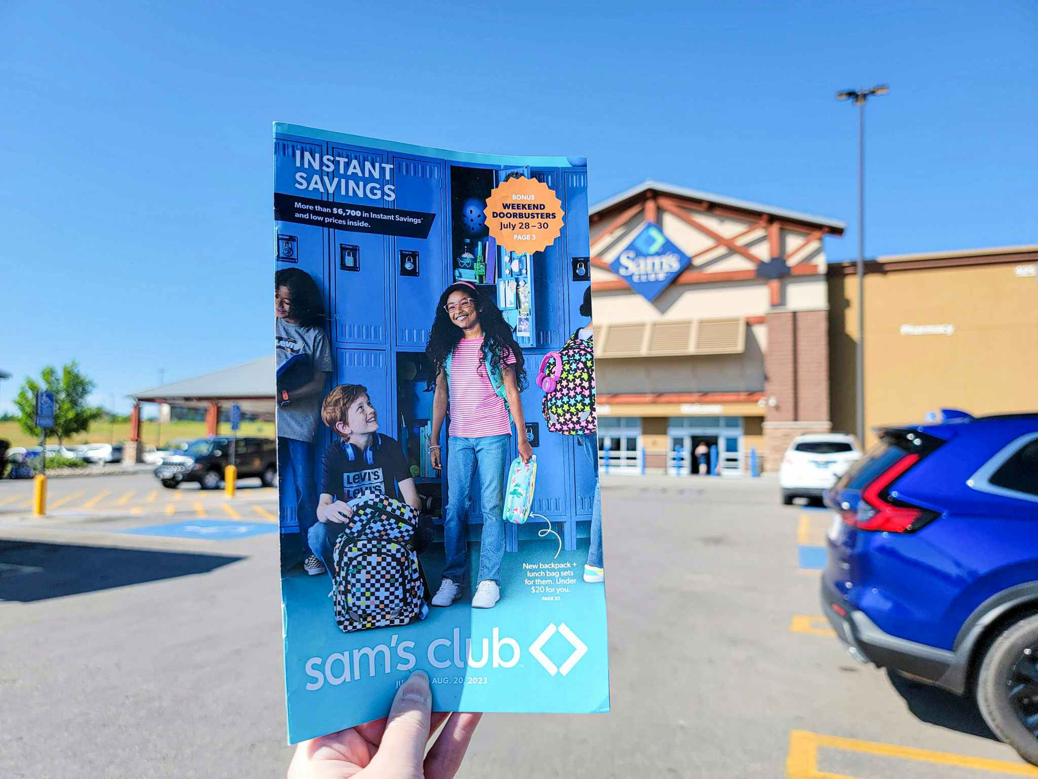 hand holding an instant savings book in front of sams club