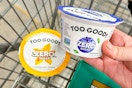 hand putting a cup of two good yogurt in shopping cart