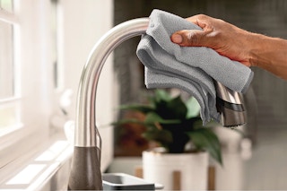 Lifestyle image of a Rubbermaid cloth being used to wipe off a kitchen faucet 