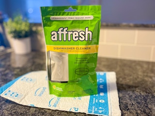 package of affresh dishwasher cleaner tablets sitting on top of an amazon envelope on a counter top